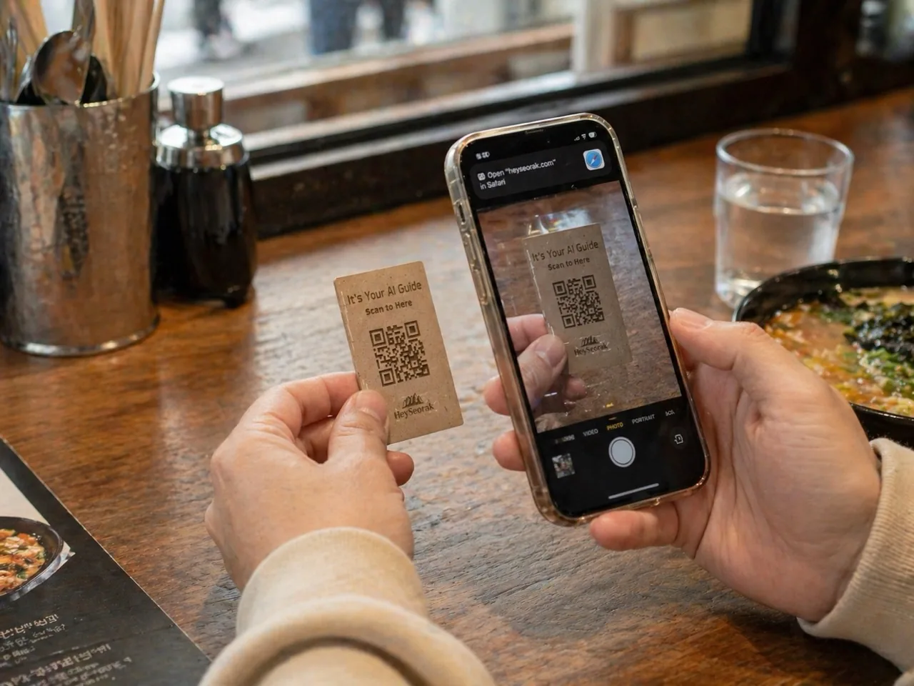 A guest scanning a HeySeorak QR card at a restaurant table